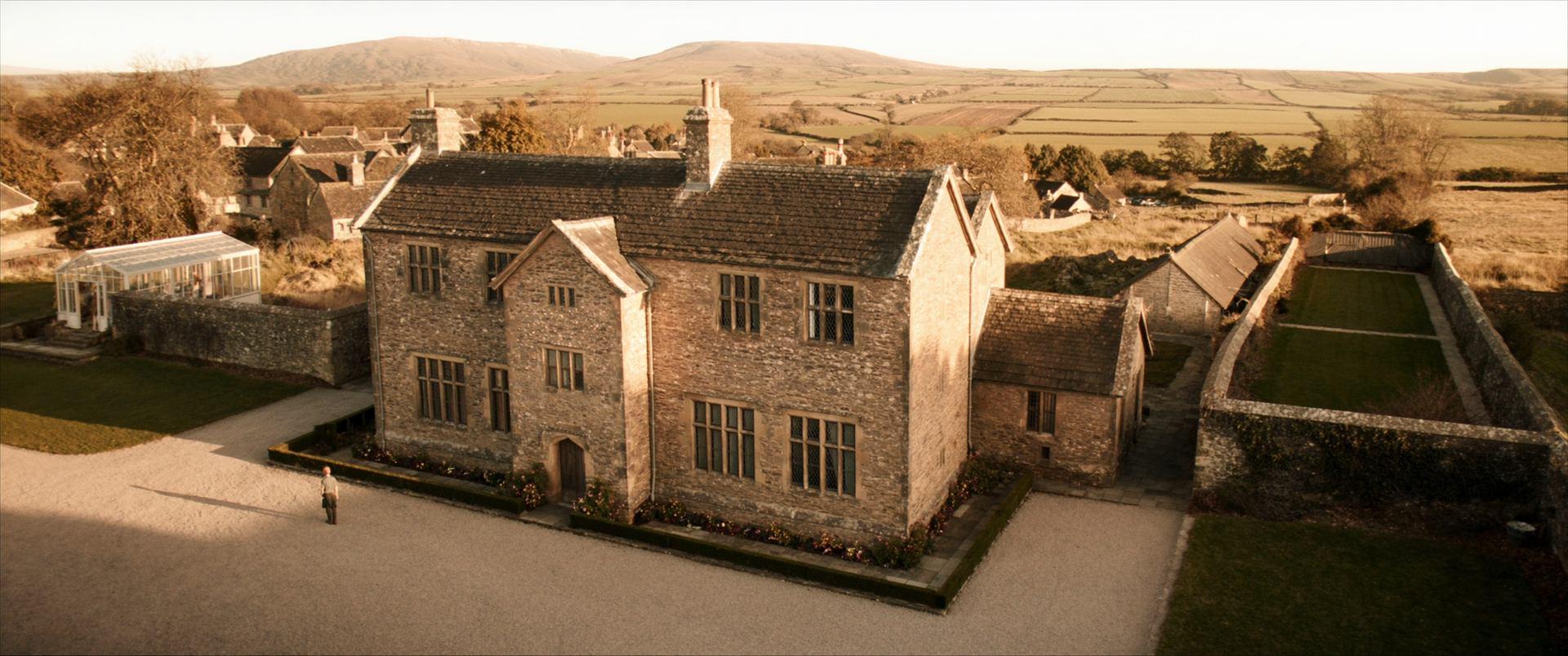 Wrenfell from the air at dusk — the hall, its courtyard, the walled garden and the dales beyond