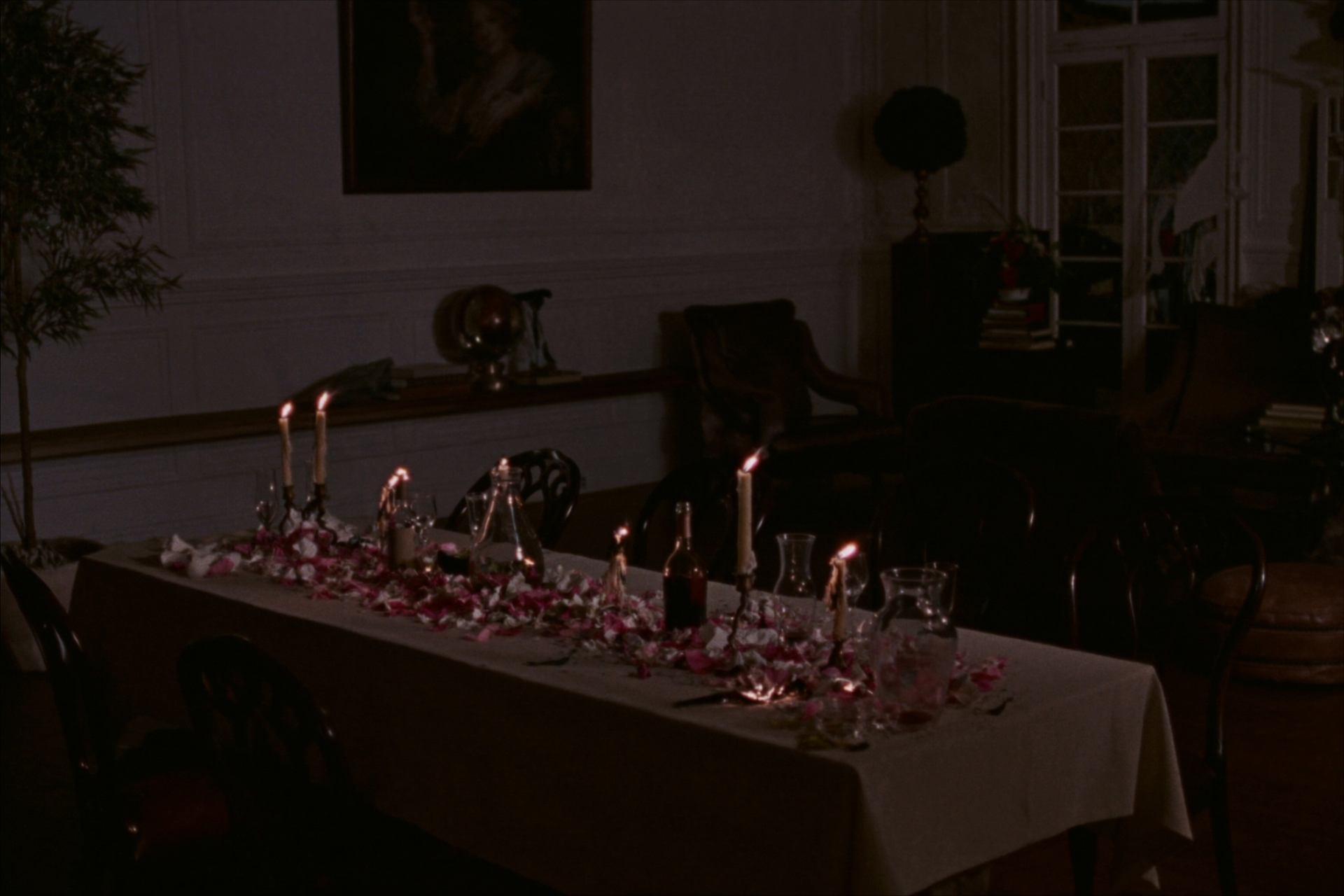 The long table late in the evening, lit only by candles burnt half down